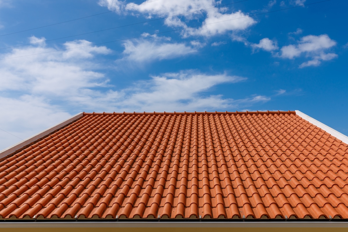 Red tiles panels roof under blue sky