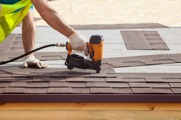 Construction worker putting the asphalt shingles